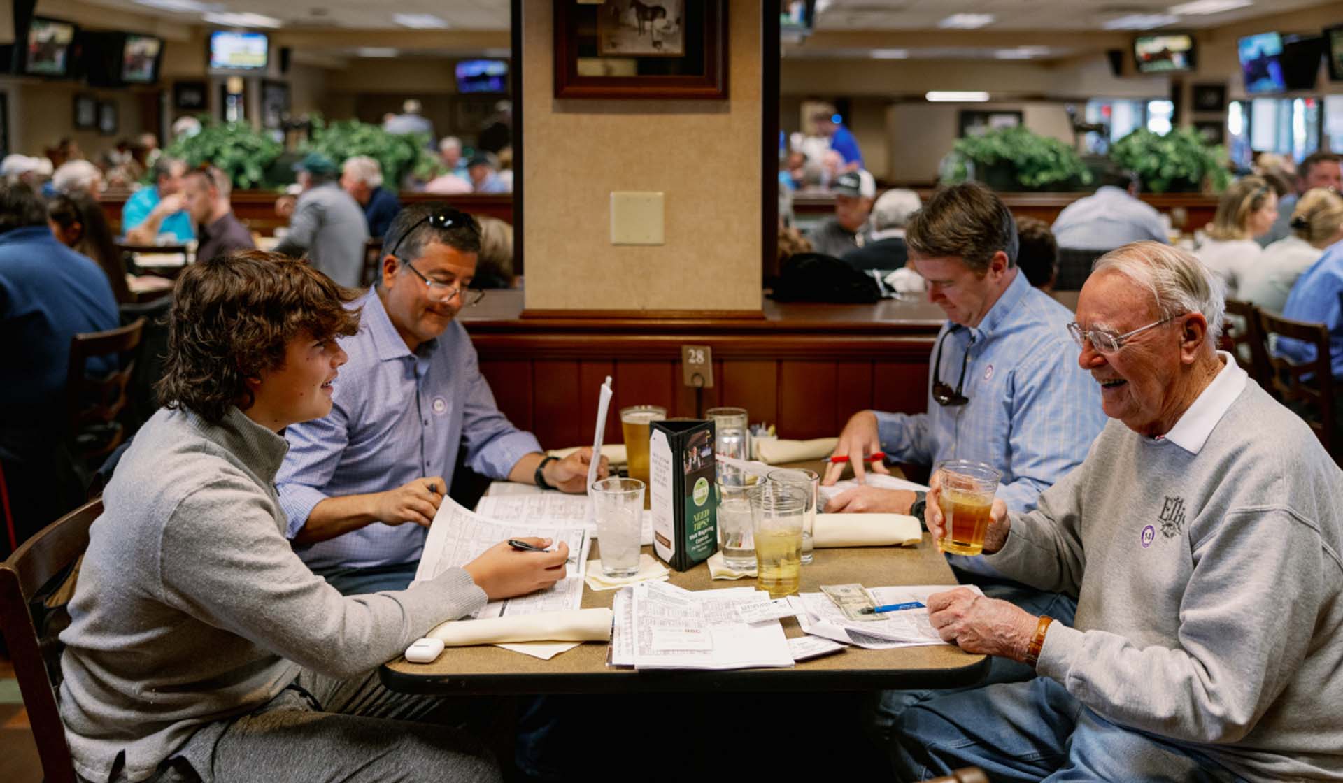 A candid photo of four men from the same family enjoying a meal together in the Equestrian Room.